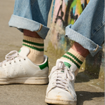 Man wearing Escuyer Men Striped Ankle Socks Ecru / Blue / Orange with Stan Smith sneakers — retro summer style