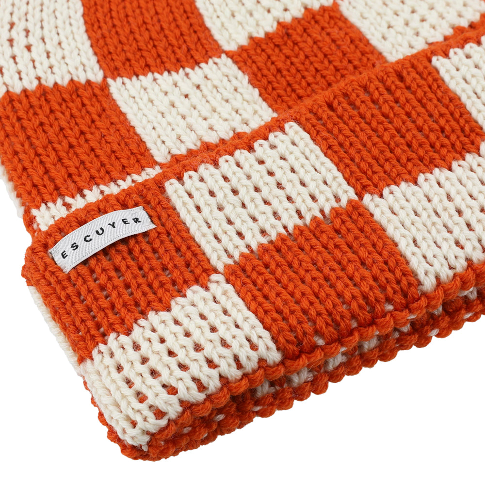 Side view of orange and ecru checkered knit merino beanie