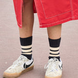 Woman wearing black and ecru striped crew socks by Escuyer, made in Portugal