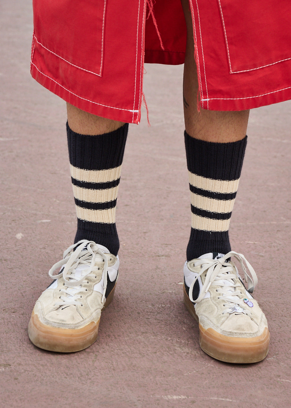 Man wearing orange and ecru striped crew socks by Escuyer, made in Portugal
