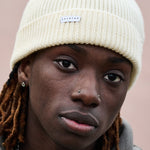 Person wearing a cream ribbed merino wool beanie by Escuyer