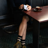 Person wearing black socks with ecru stripes made of wool and cashmere (made in Portugal)