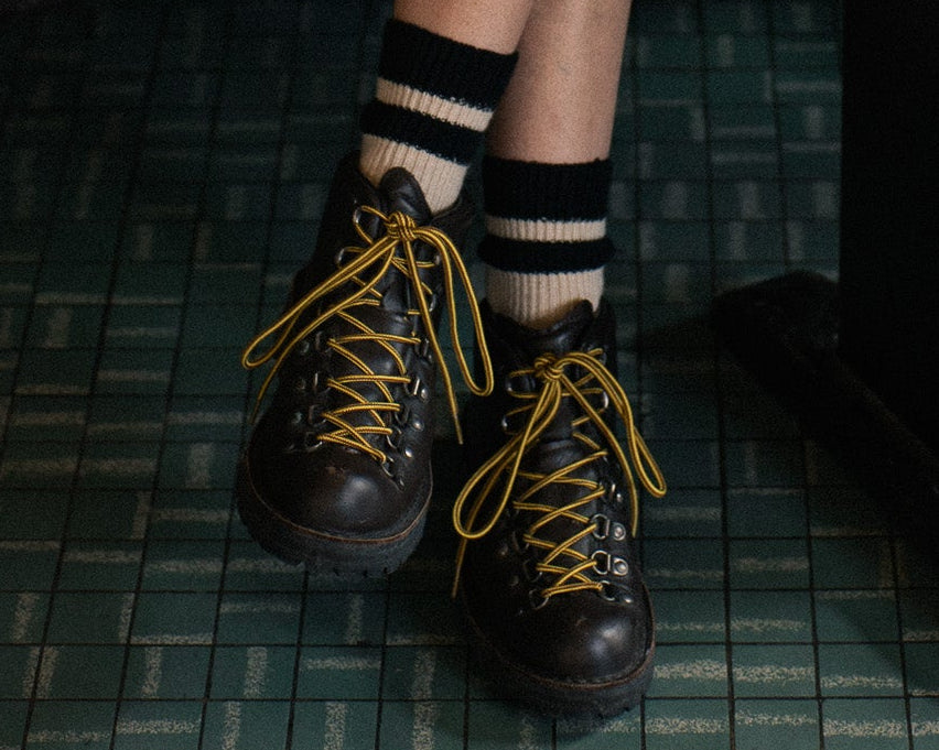 Person wearing black socks with ecru stripes made of wool and cashmere (made in Portugal)